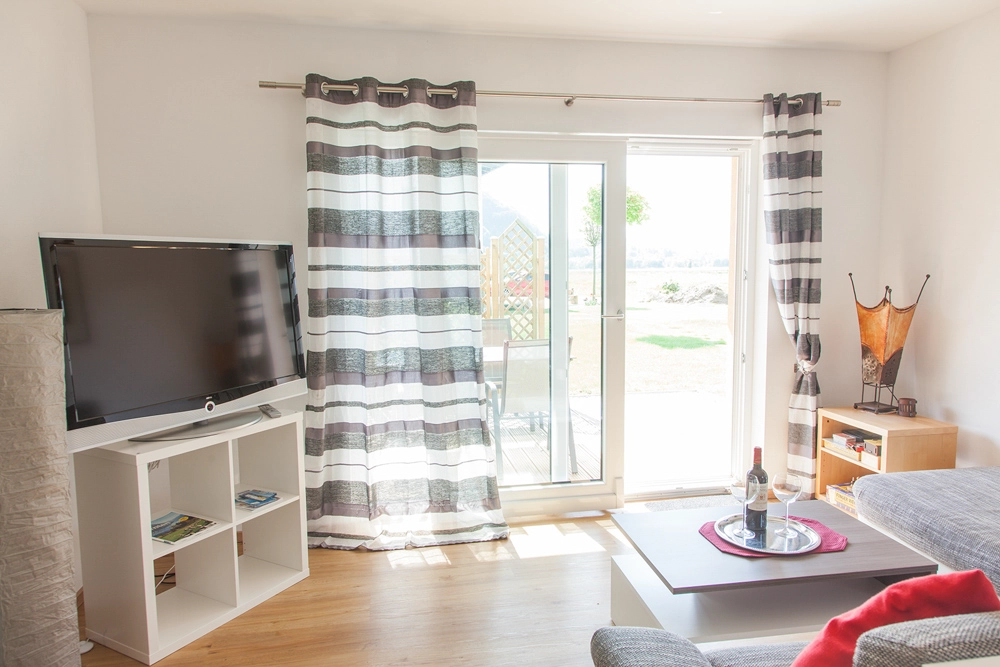 „Hahns Herberge“ – Wohnzimmer Foto mit Blick auf die Terasse - klare Linien, hell und freunlich.